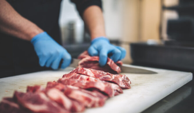 A butcher cuts meat in Peoria IL